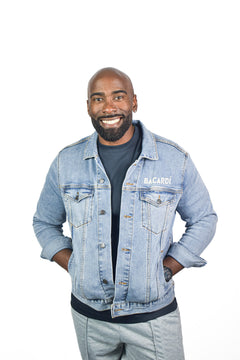Front view of Bacardi light-wash denim jacket worn by male model, hands in pockets, smiling